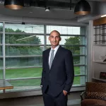 Man in professional wear standing in office hallway