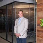 Man in professional wear standing in office hallway