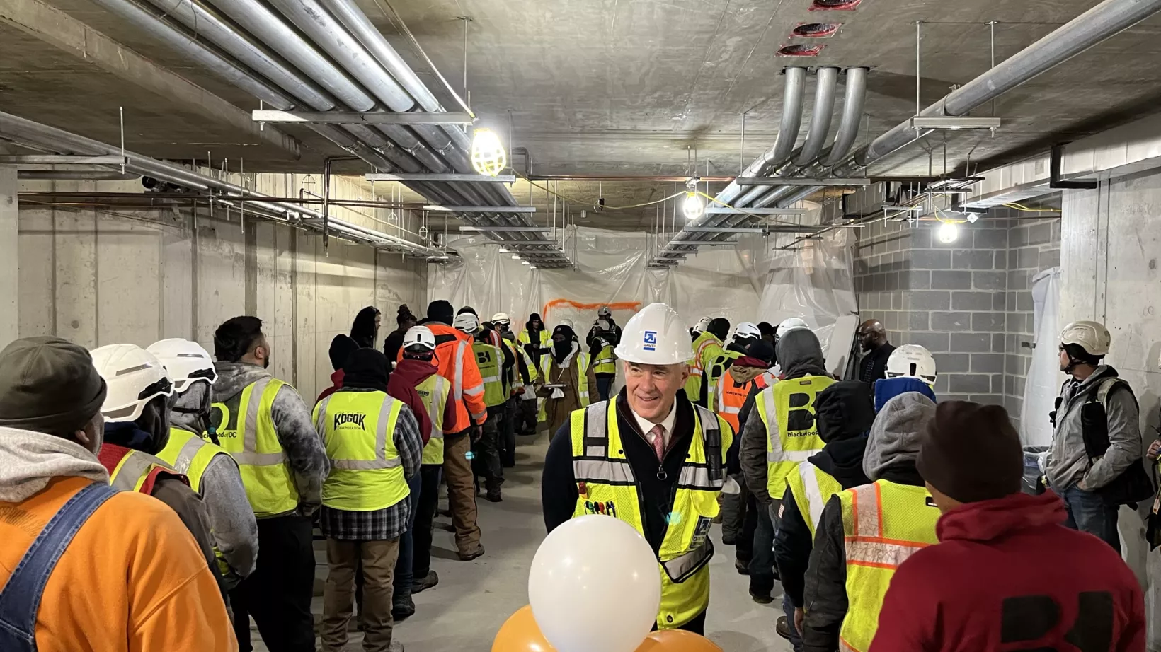 Jim Davis and on-site workers celebrate topping out at Reunion Square