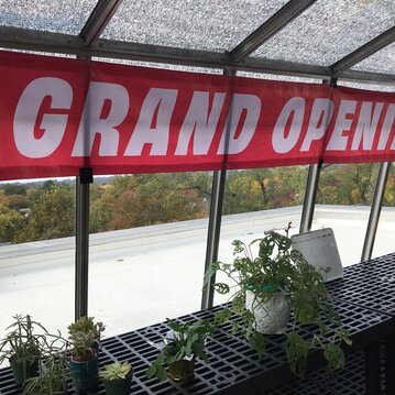 Grand opening banner sits above new plants at greenhouse