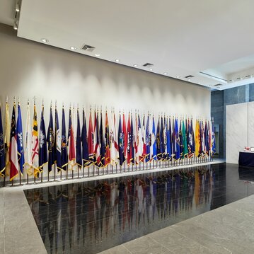 The front desk at the Military Women's Memorial has many flags flags on display, from the American flag to individual states.