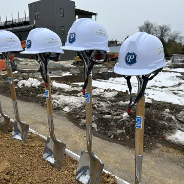 Construction helmets atop DAVIS branded shovels used in groundbreaking