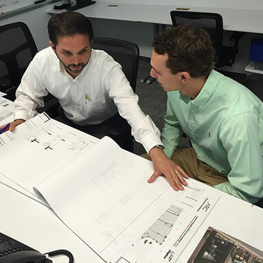 Two persons reviewing construction drawings 