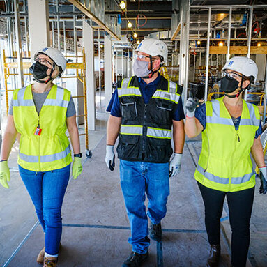 three construction workers walking a project site 