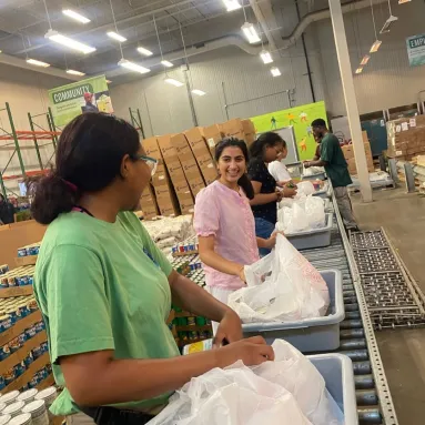 Two interns in a food bank interacting