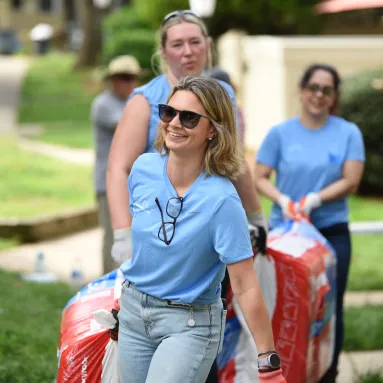 women carrying mulch during volunteer event