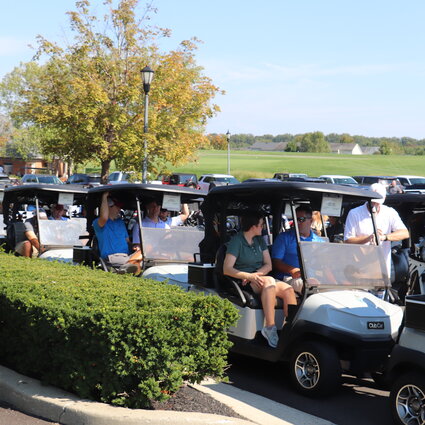 Groups of people sitting in golf carts