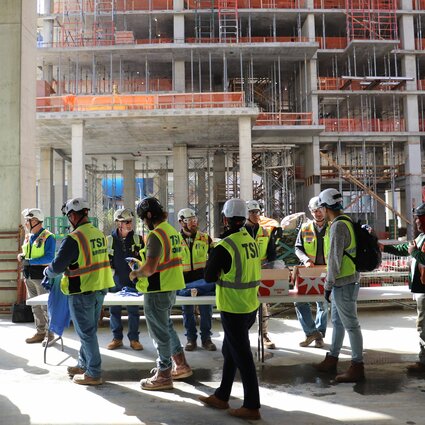 A group of construction workers walks through a working site.
