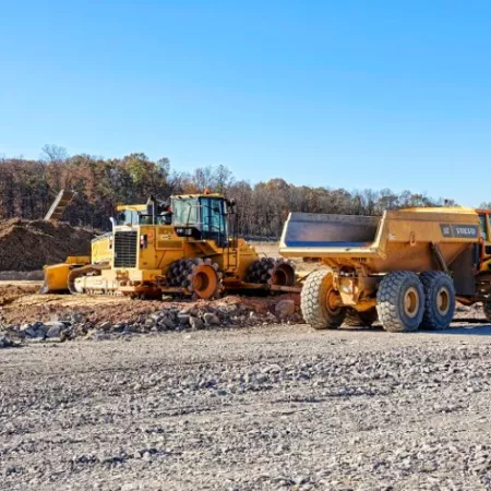Construction site featuring excavators and gravel.
