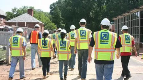 people in safety vests and hard hats walking away