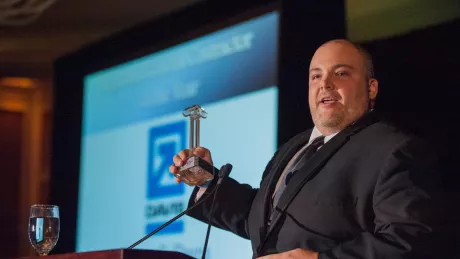 Man presenting award at podium