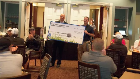Two men holding a large check