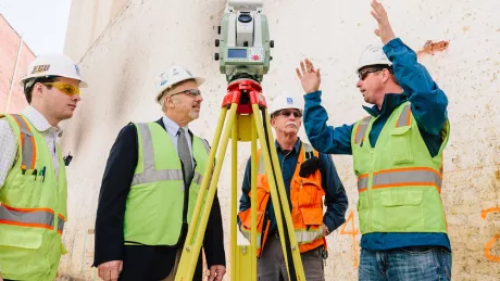 Construction workers discussing laser scanning