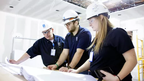 Three construction workers looking at a drawing