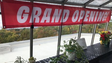 Grand opening banner sits above new plants at greenhouse