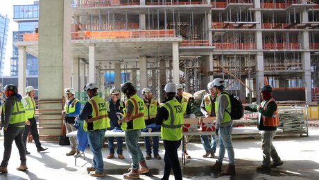 A group of construction workers walks through a working site.