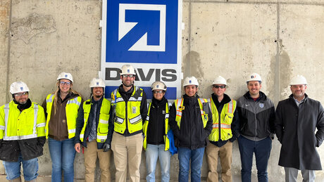 A group of construction workers poses in .front of the DAVIS logo