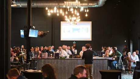 Audience at an event watches a speaker.