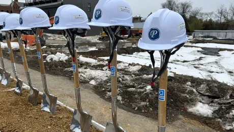 Construction helmets atop DAVIS branded shovels used in groundbreaking