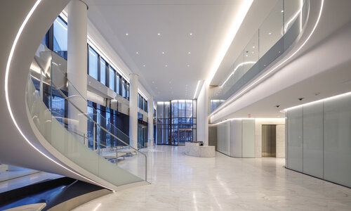A lobby with marble floors and a helical stair.
