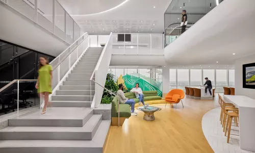 An interconnecting staircase in an office setting, with people working in the space.