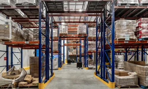 The inside of a storage facility, with shelves and pallets