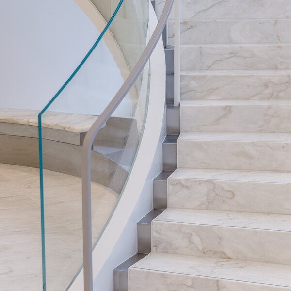 Close up of a monumental staircase with metal handrails and marble steps.