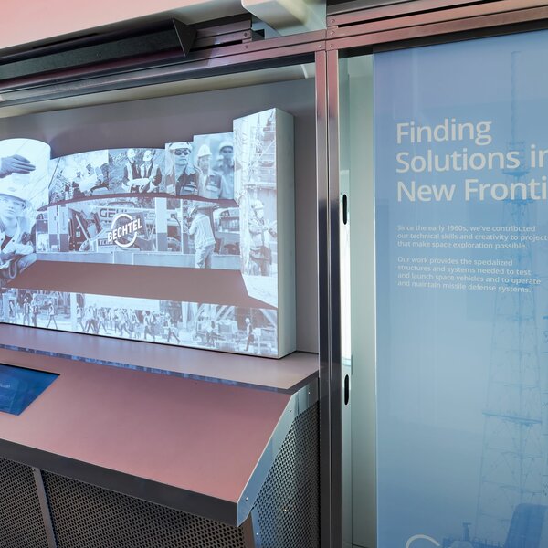 A screen with a historical photo of the Bechtel corporation, with designed text next to it describing the company's history