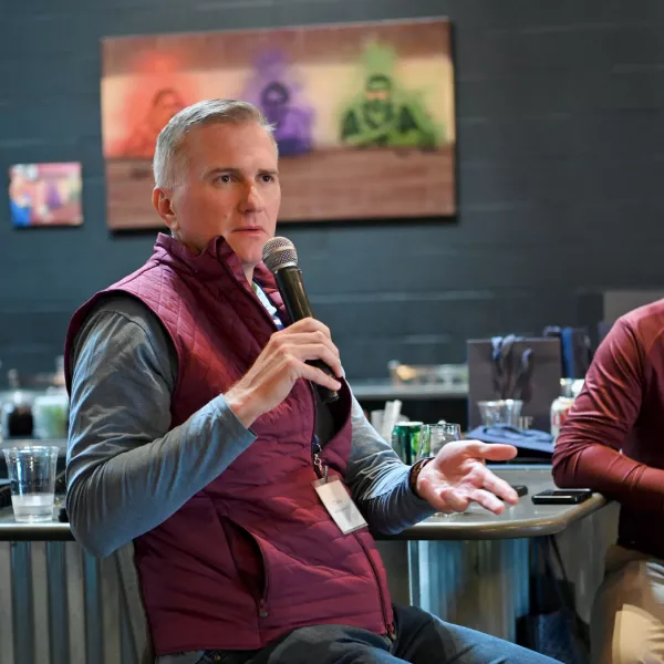 A man holds a mic next to other people.