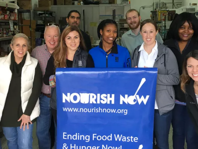 group of people holding Nourish now sign